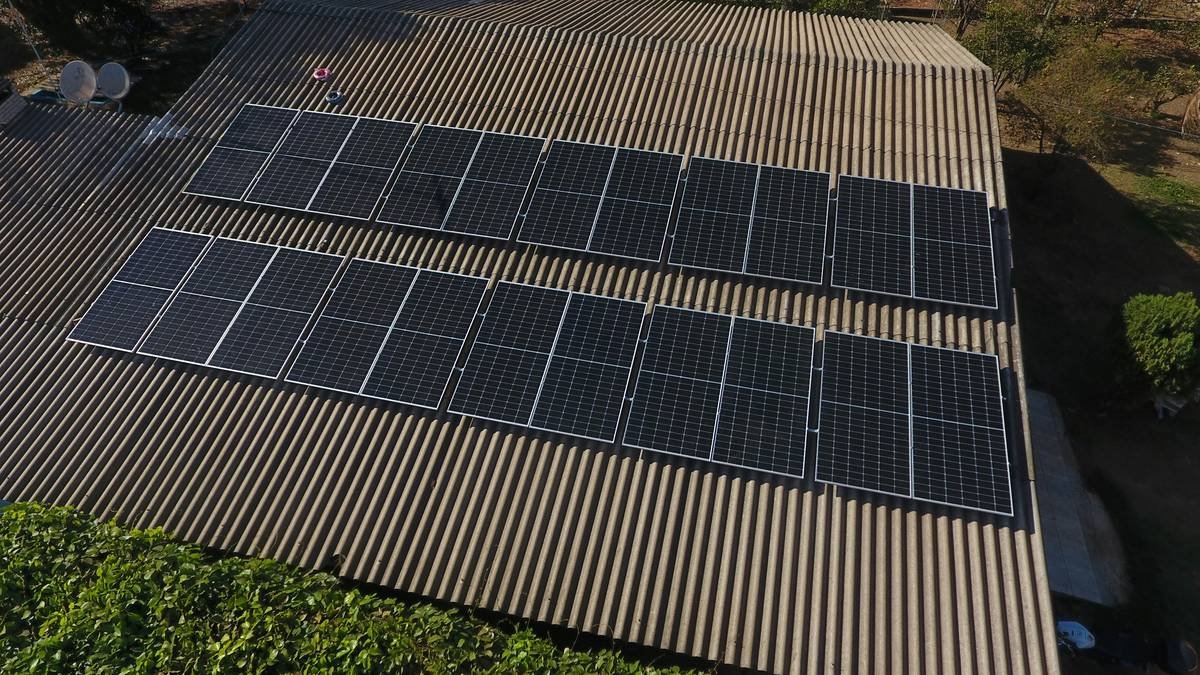 Diagram showing sunlight hitting front of bifacial panel and reflected light from ground hitting rear side
