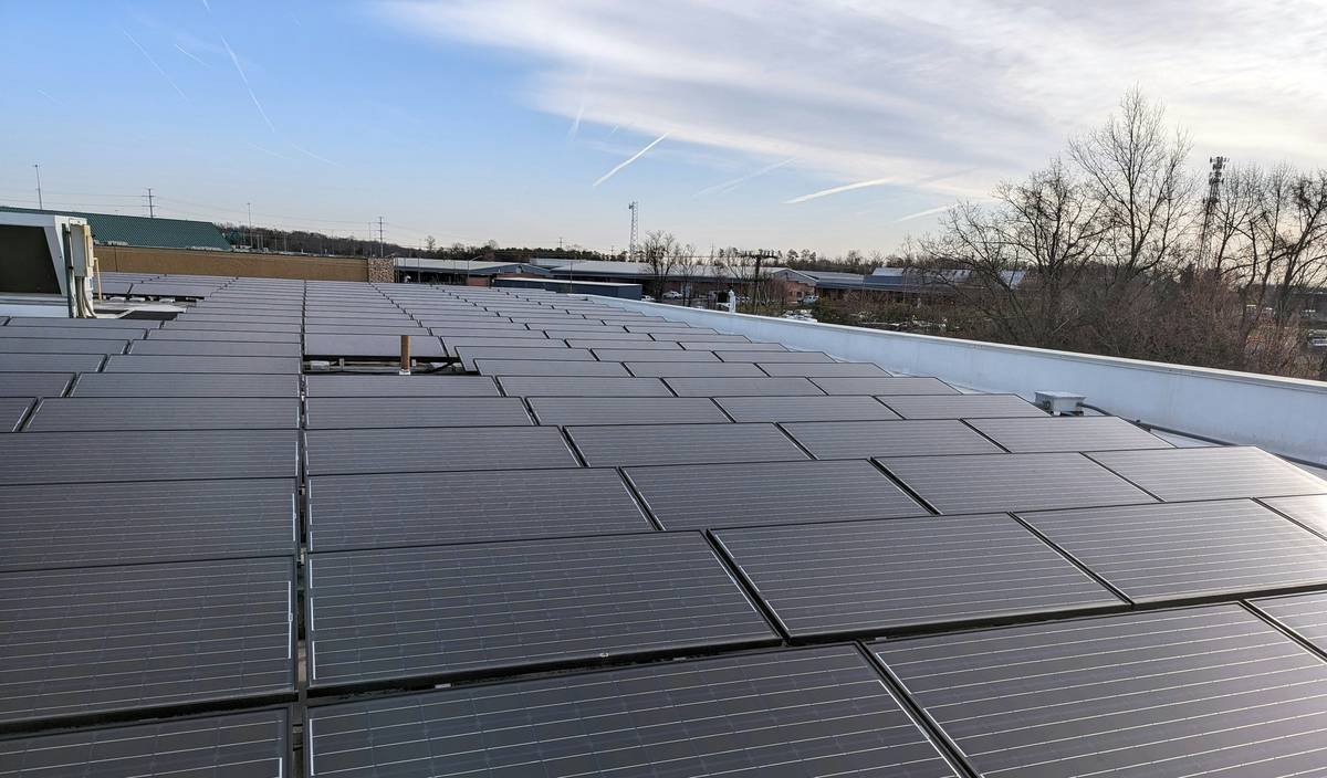 bifacial solar panels installation guide showing elevated ground-mounted array over white gravel